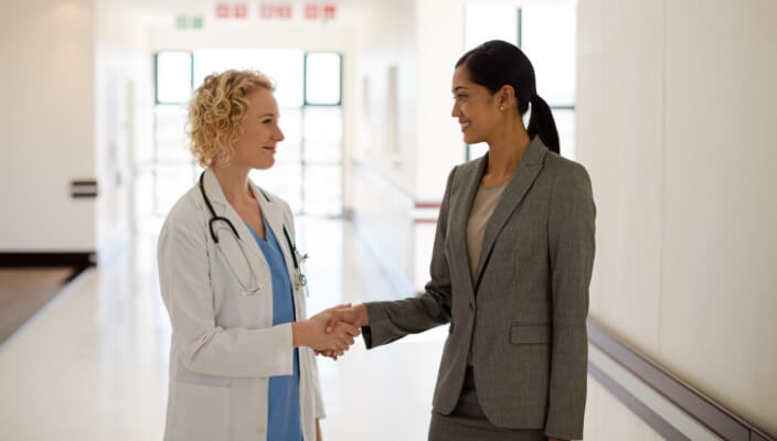 dermatologist shaking hands with business woman