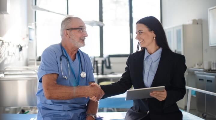Physician shaking hand of business woman