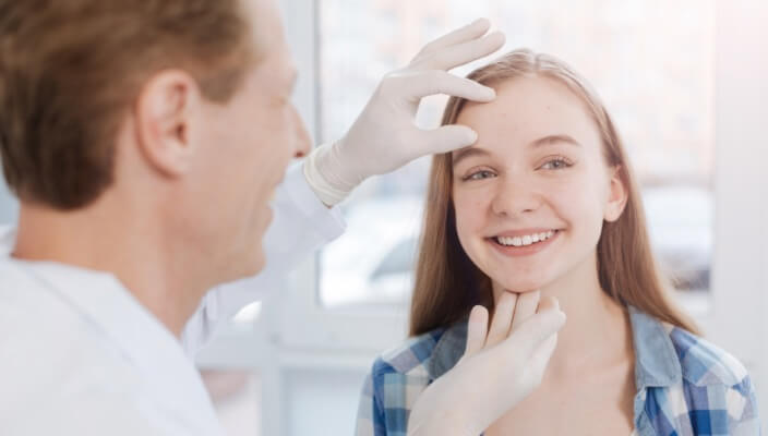 Dermatologist inspecting patient's face